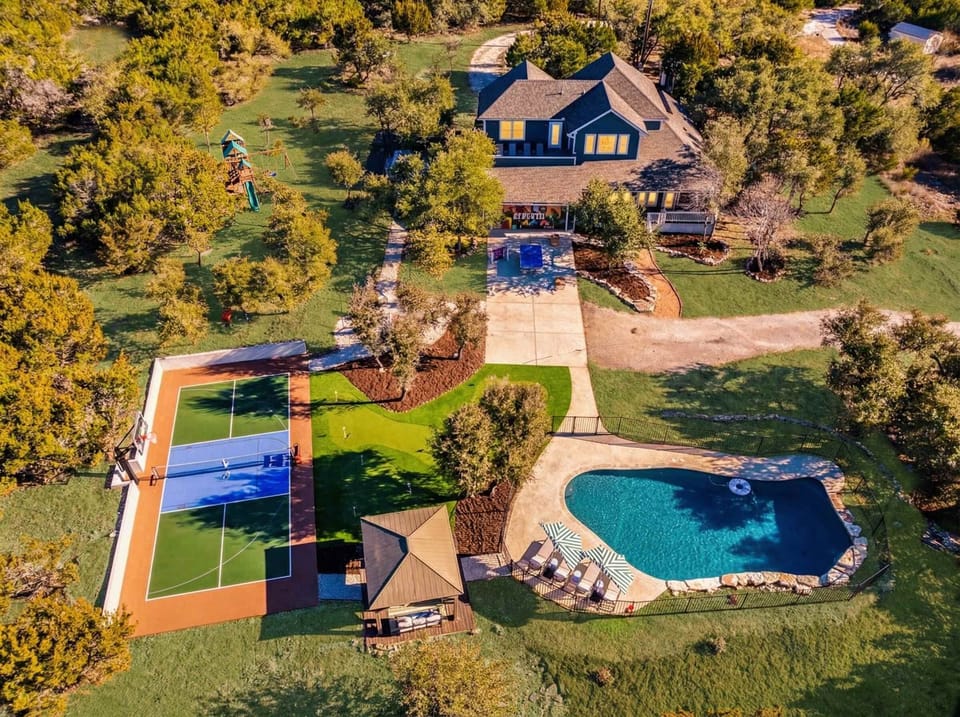 A bird’s-eye view says it all — this backyard was made for unforgettable group getaways. Dive into the pool, rally on the pickleball court, or practice your short game on the putt putt green.