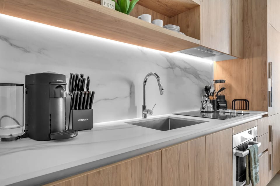 Channel your inner chef in this pristine, fully equipped kitchen! Featuring sleek wood cabinetry, elegant under-cabinet lighting, stainless appliances, and a premium coffee maker Nespresso to start your day right. Your perfect culinary space!