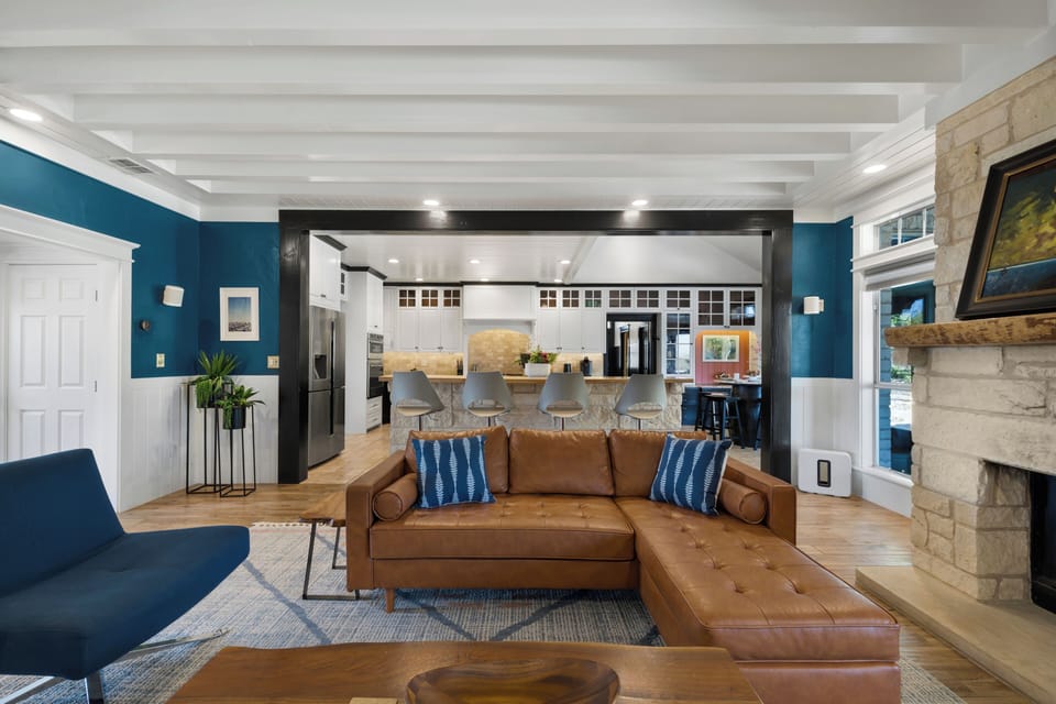 Relax in your stylish open-concept living space, where rich leather seating and vibrant blue accents create the perfect gathering spot.