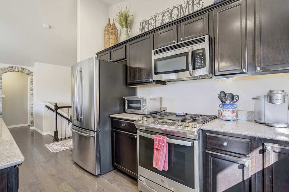 This secondary view of the kitchen highlights the gas range and toaster oven, ensuring you have everything needed for home-cooked meals. The layout is designed for efficiency with all major appliances and prep surfaces within easy reach.