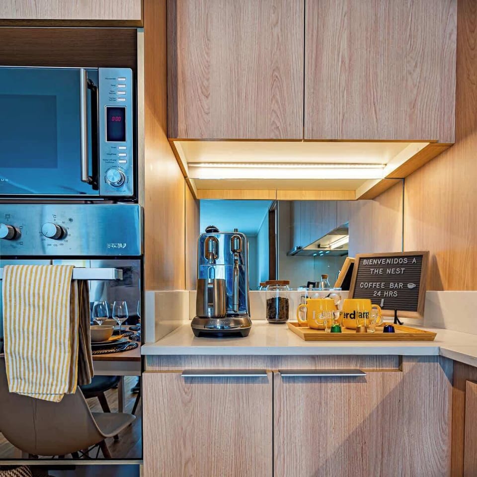 Cocina completa con estación de café/té, microondas, horno eléctrico, hornallas eléctricas, heladera y congelador.