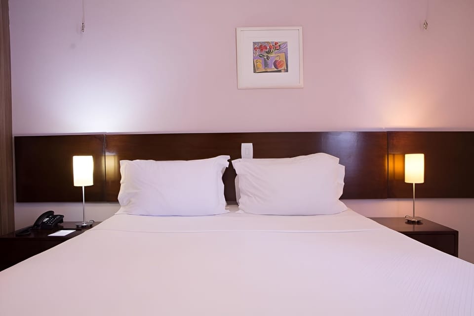 Sink into soft pillows under warm bedside glow.