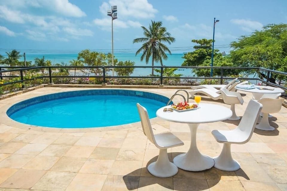 Dive into a sunlit pool with sweeping ocean views.