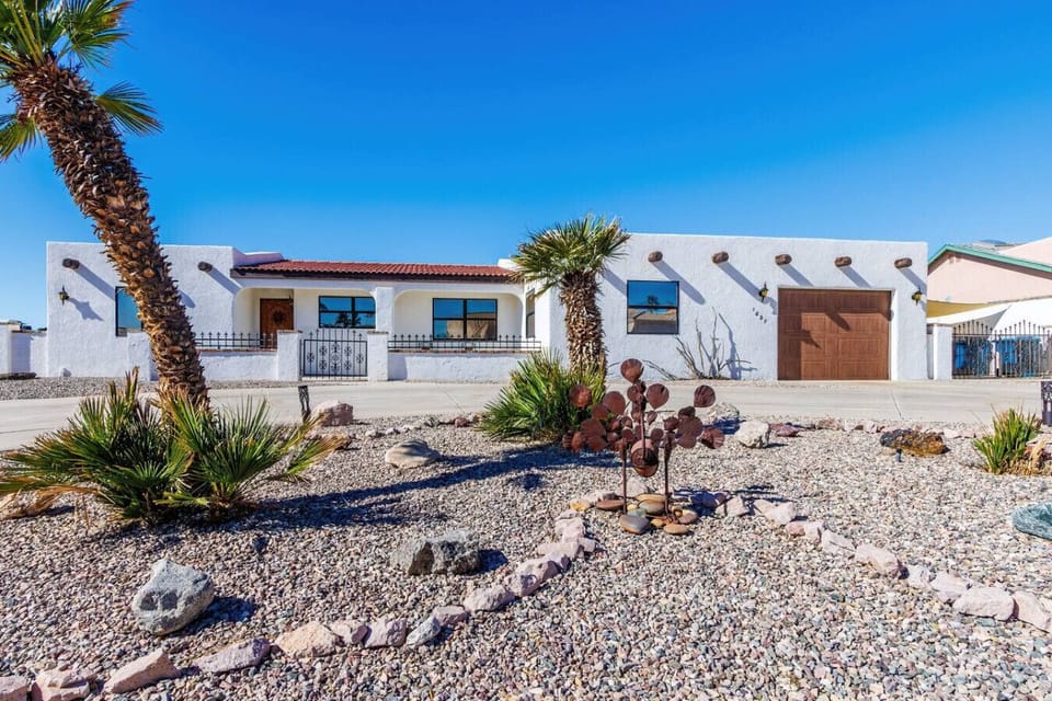 Modern architectural facade and manicured desert landscaping. Experience immediate curb appeal as you arrive at your private getaway.