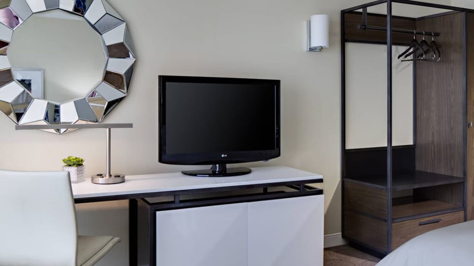 Refresh and reset with a work desk, TV, and open closet.