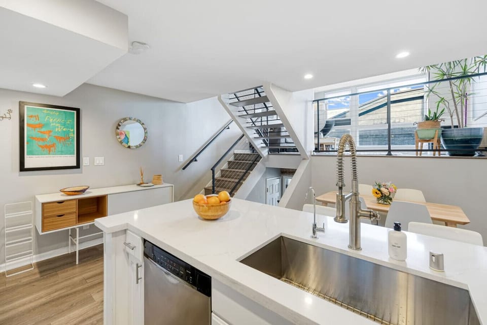 Contemporary open-plan kitchen featuring a generous island, sleek fixtures, and plenty of natural light.