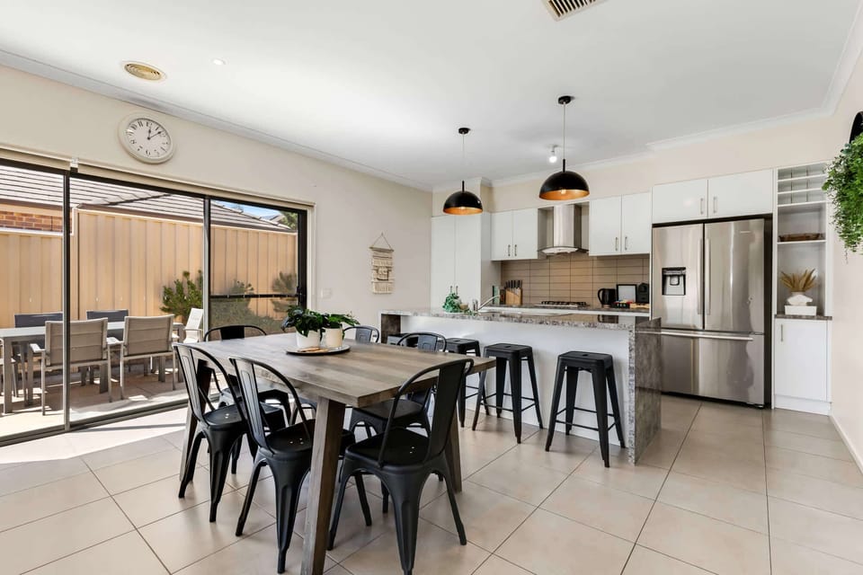 Open plan kitchen & dining alongside an outdoor table setting.