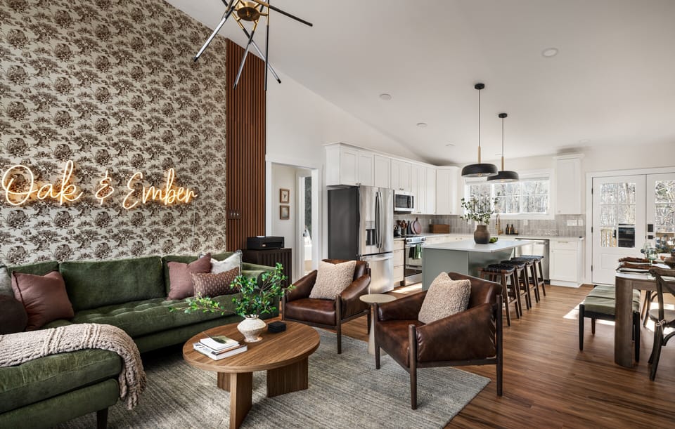 Open living, dining, and kitchen area with seating and deck access