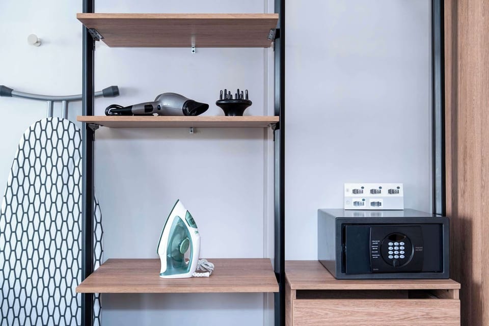 Closet with iron, ironing board, hair dryer, and safe for your personal belongings. 