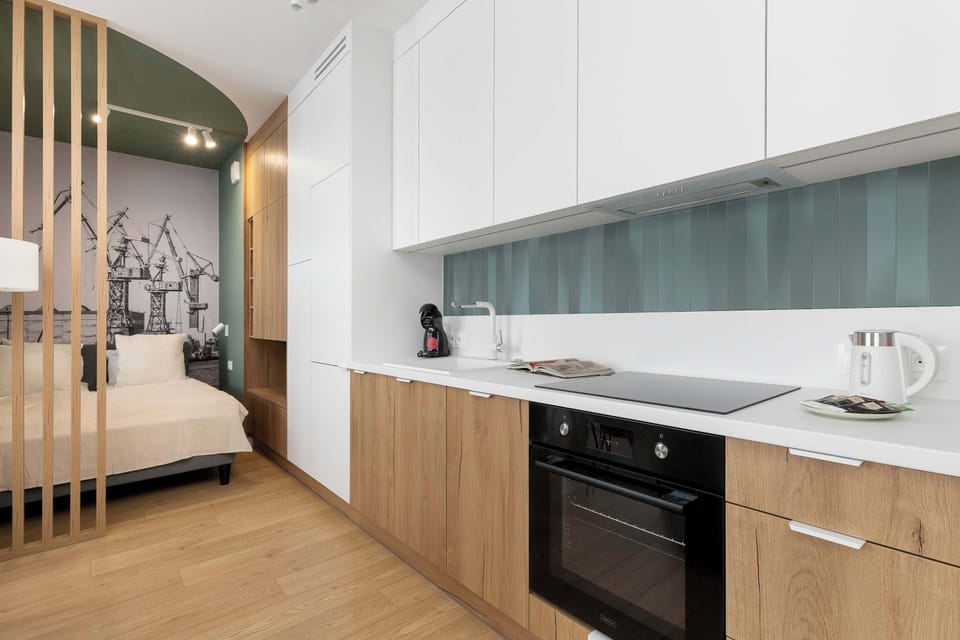 Modern kitchenette with white upper cabinets and wooden lower fronts, offering a clean design and practical layout for everyday cooking.
