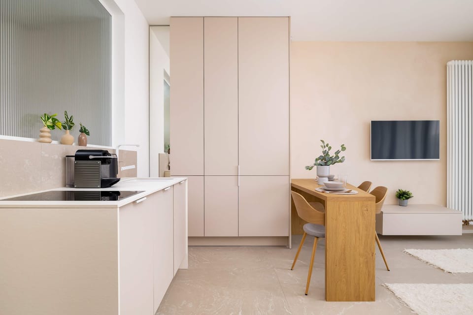 The compact kitchenette is integrated into the living area, featuring white cabinetry and a convenient breakfast bar.