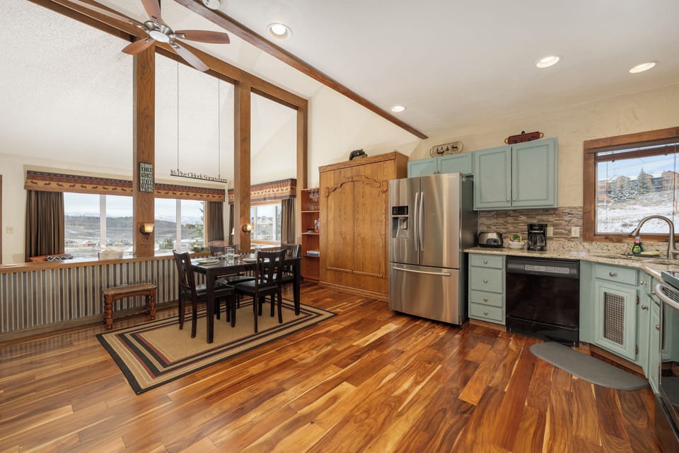 Your spacious kitchen and dining area at Mountainside Unit B-8 features stunning hardwood floors, rustic beams, and modern appliances for memorable meals.