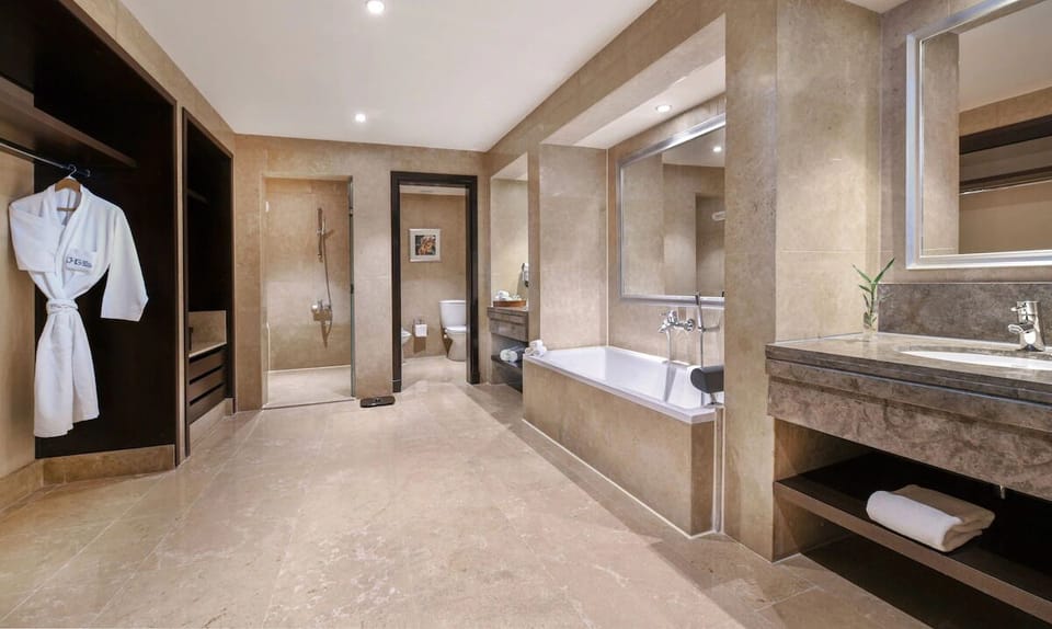 Refresh under a rainfall shower in a marble-finished bath.