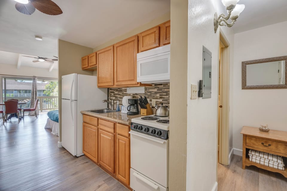 Your fully equipped kitchen features warm wood cabinetry, modern appliances, and stylish tile backsplash - perfect for preparing meals during your stay.