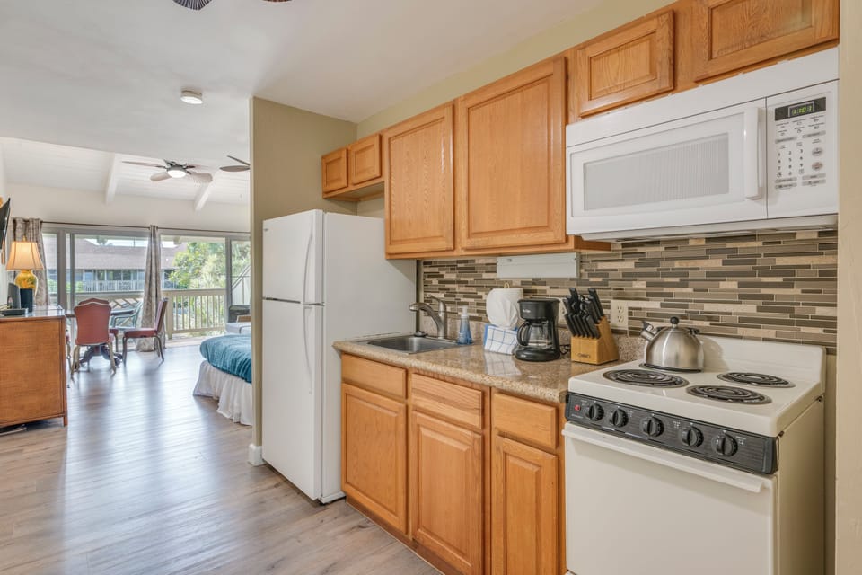 Your fully equipped kitchen features warm wood cabinets, granite counters, and modern appliances—perfect for preparing meals during your stay.