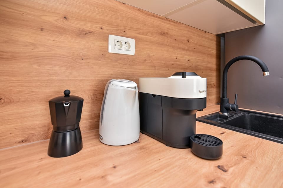 A Nespresso Vertuo coffee machine, a kettle, and a moka pot.