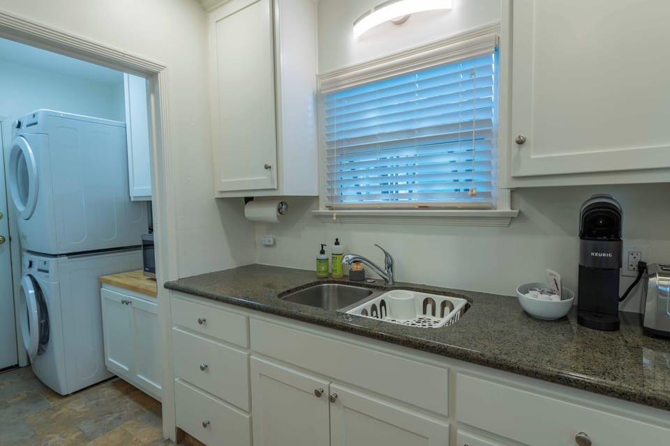 Your bright kitchen features granite counters, modern appliances, and convenient access to laundry facilities for extended stays.
