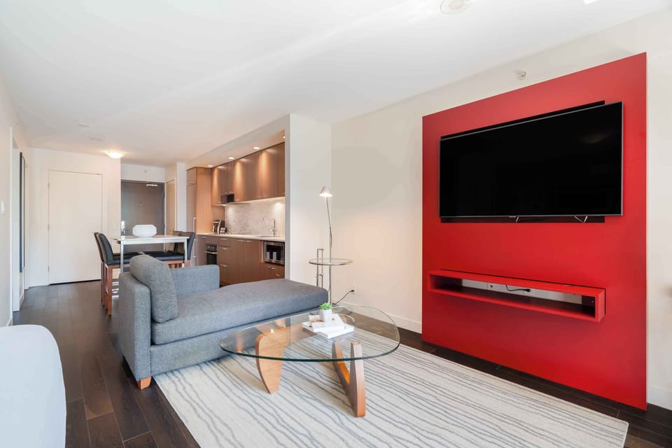 Contemporary living area with a sofa bed, stylish décor, and a wall-mounted TV for relaxing evenings.