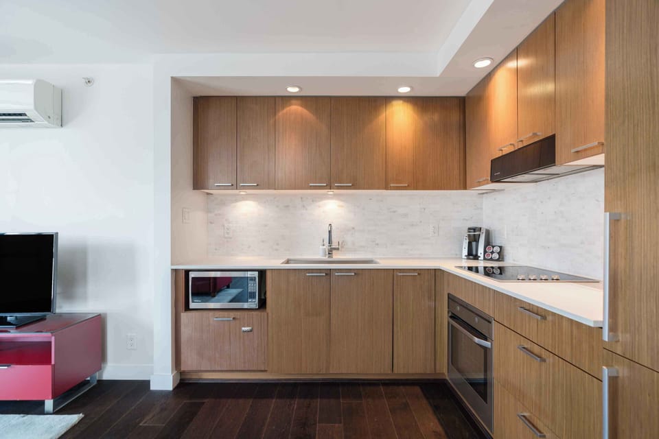 Fully equipped modern kitchen featuring sleek cabinetry, stone countertops, and full-size appliances for extended stays.