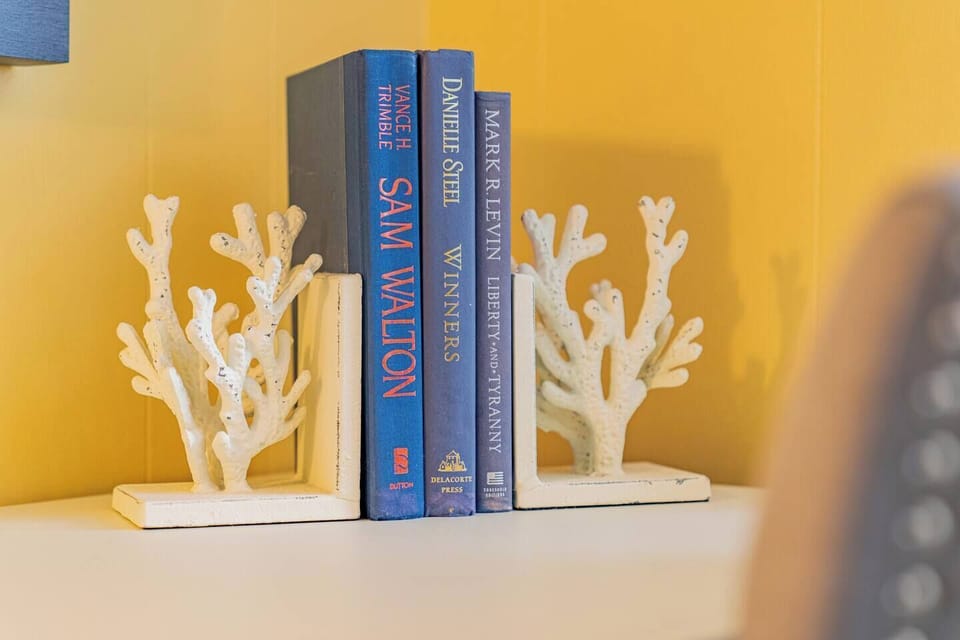 Coastal-style shelf with coral bookends and a bright, cheerful accent.