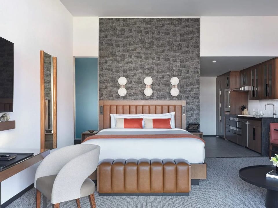 Sink into crisp linens beneath warm, modern statement lighting.