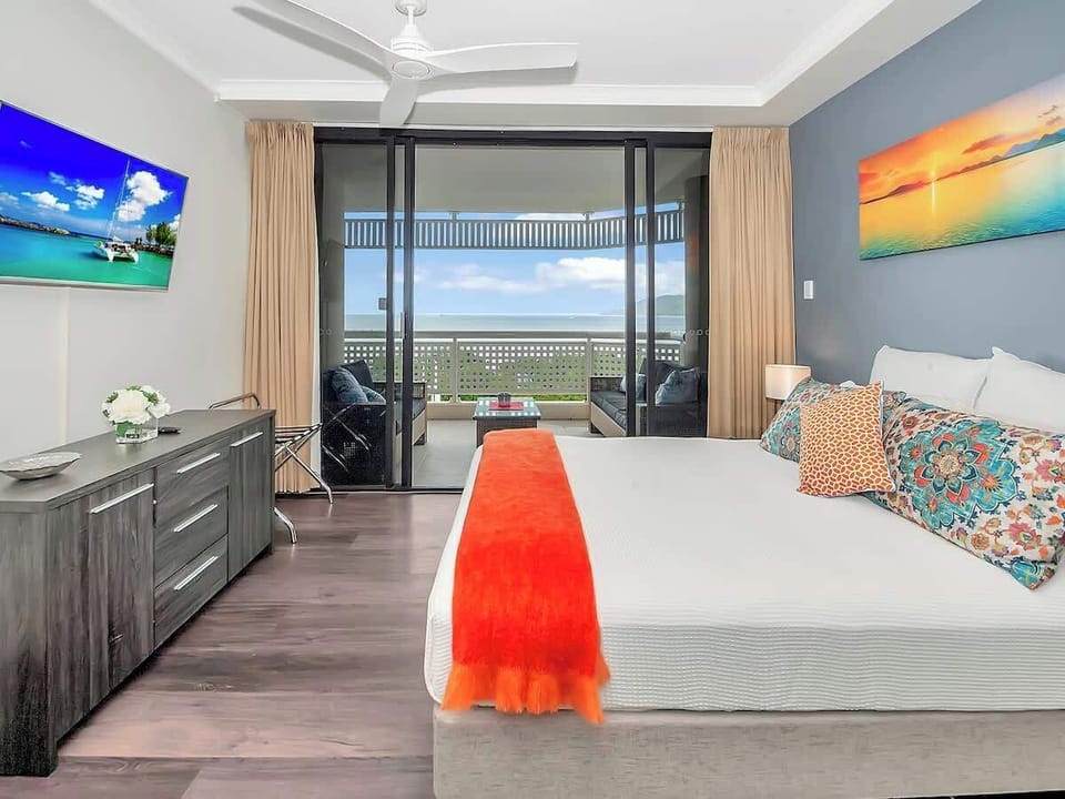 The master bedroom is beautifully appointed with a queen-sized bed, wall-mounted TV and direct access to the balcony. 