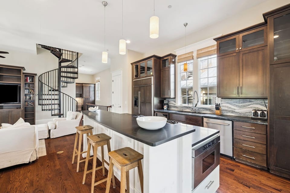 Your gourmet kitchen features rich walnut cabinetry, sleek countertops, and a perfect island for morning coffee or evening wine with loved ones.