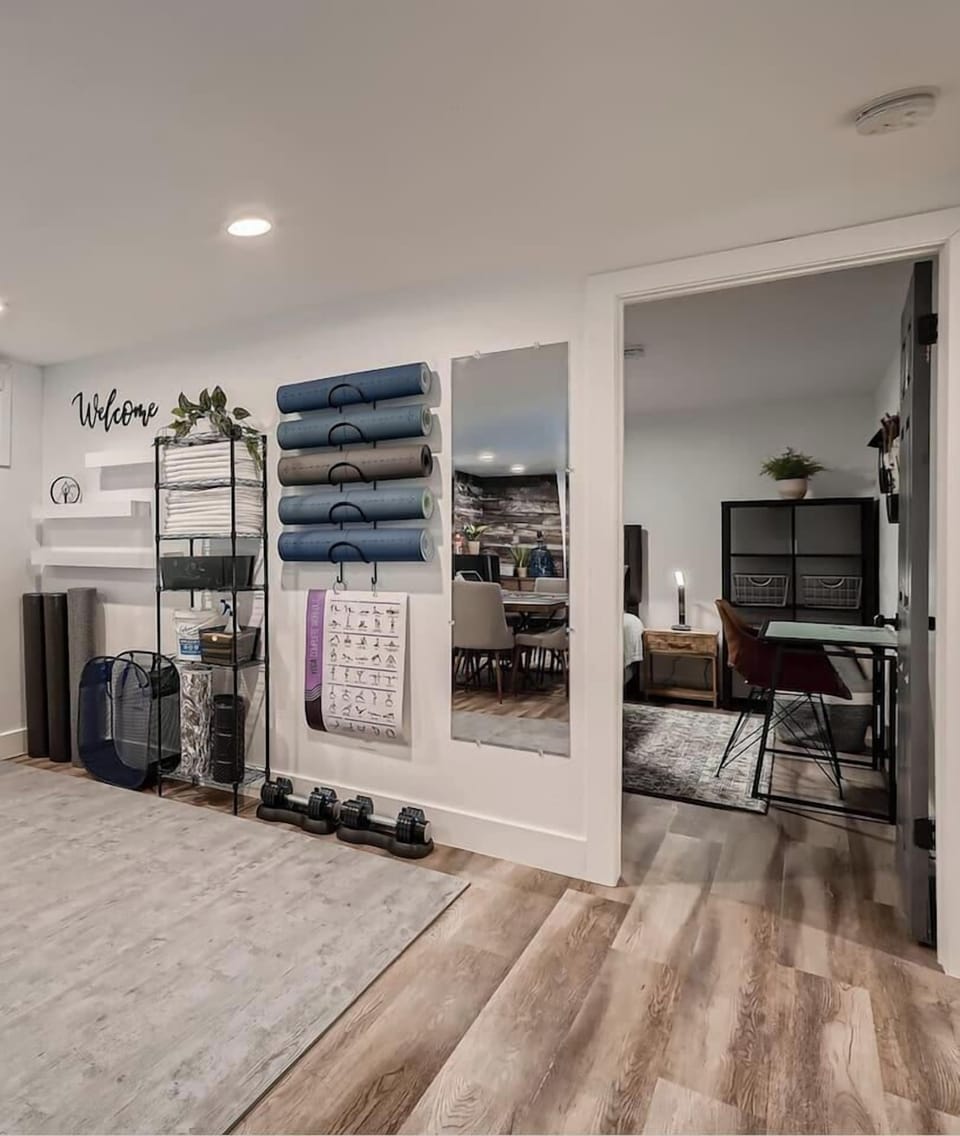 Game room with shuffle board, poker, living room with smart TV, and gym area