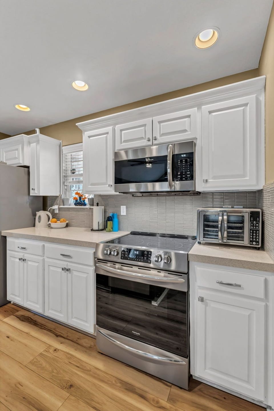 Modern kitchen with full-size appliances, air fryer oven, and stocked essentials