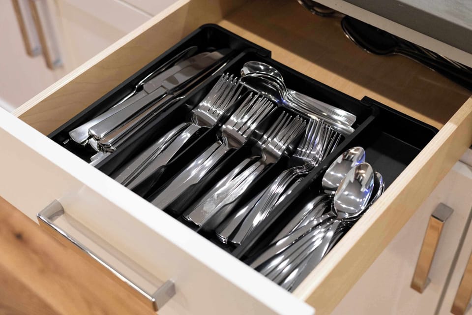 Fully stocked cutlery drawer with essential utensils neatly arranged for easy access. Everything you need for preparing and enjoying home cooked meals is right at your fingertips.