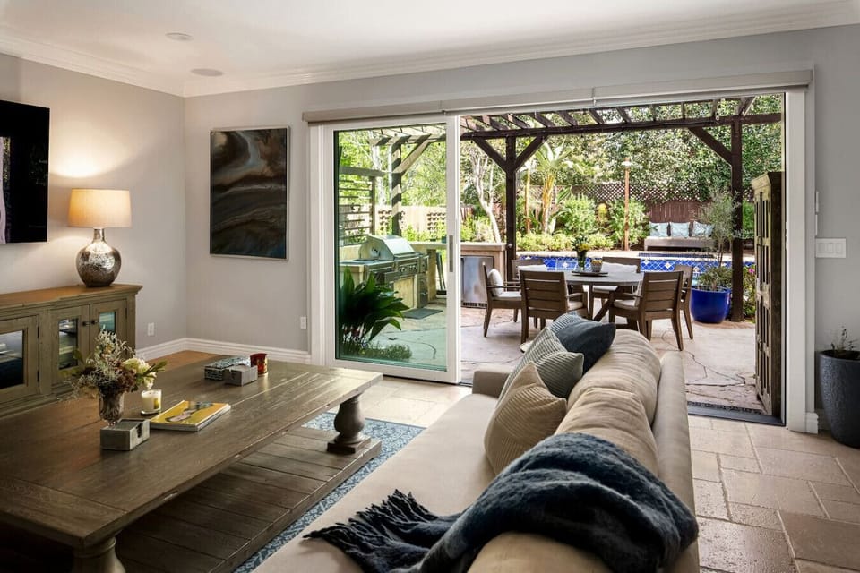 Step into relaxation—this living room opens effortlessly to a sunlit patio and sparkling pool.