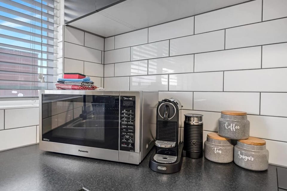 Modern kitchen appliances including coffee machine, microwave, and essentials for convenient stays.