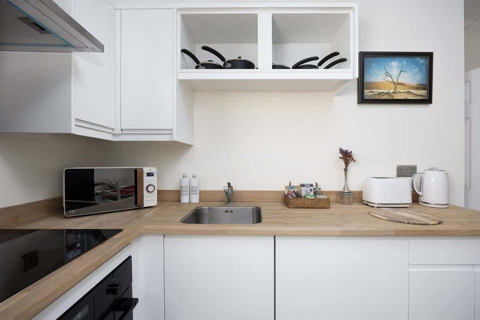 Whip up your favorite meals in this bright, all-white kitchen. Compact yet fully equipped with modern appliances. Perfect for cozy breakfasts, home-cooked dinners, or a coffee break in style.