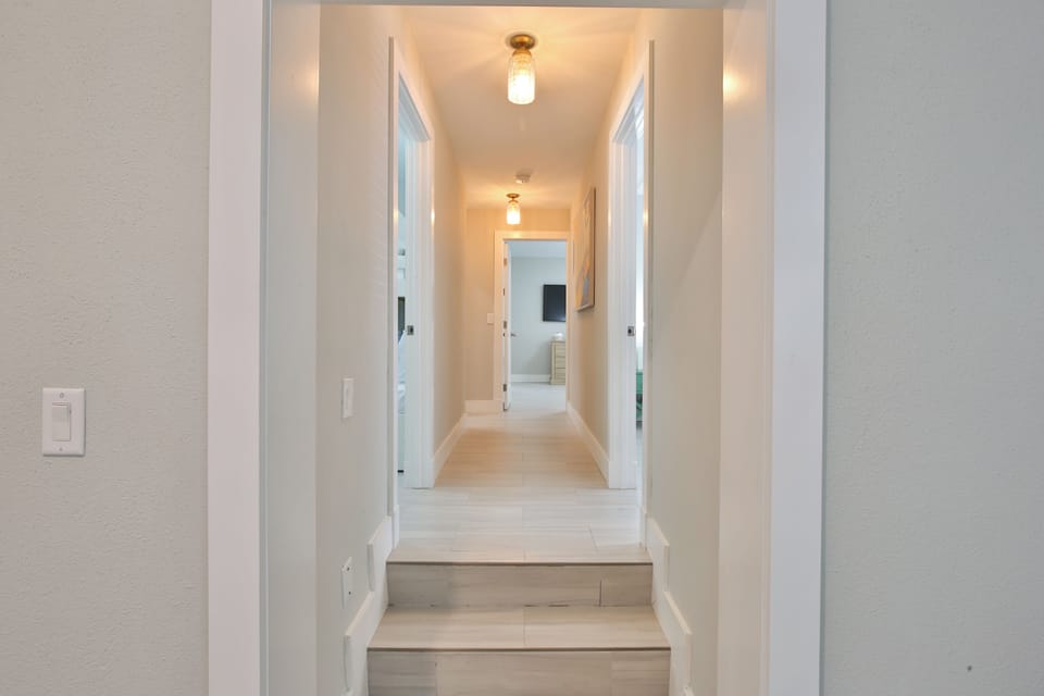 Step into your bright, modern hallway where warm lighting guides you through this thoughtfully designed space.