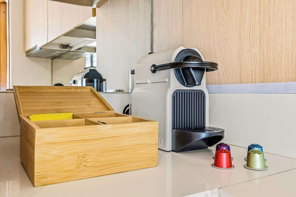Rincón de café con máquina Nespresso y cápsulas de cortesía, ideal para disfrutar un momento de relax. Perfecto para comenzar el día o hacer una pausa, acompañado de una atmósfera cálida y moderna.