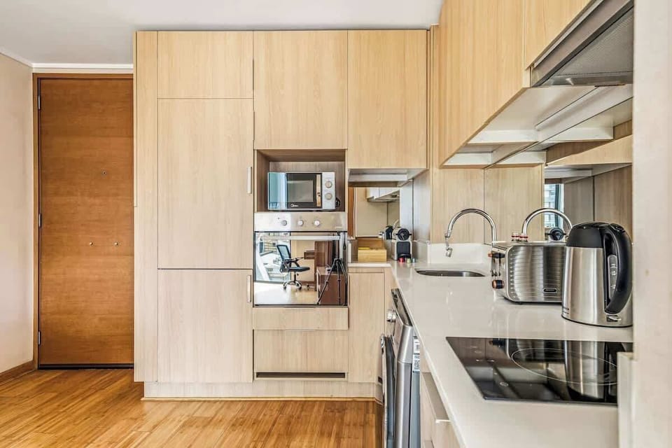 Cocina moderna y totalmente equipada con horno, microondas, cafetera, tostadora y lavadora. Espacio integrado al comedor, ideal para disfrutar comidas o trabajar cómodamente en un ambiente cálido y funcional.