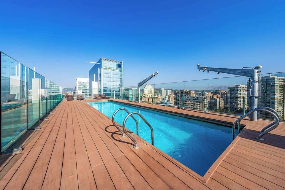 Piscina en la terraza del piso 18, con vistas panorámicas a la ciudad y la cordillera. Abre solo durante la temporada de verano. Ideal para relajarse y disfrutar del paisaje.