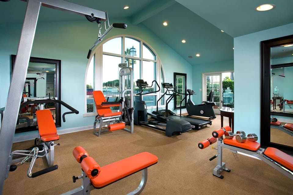 Train comfortably with cardio machines in a sunlit fitness studio.
