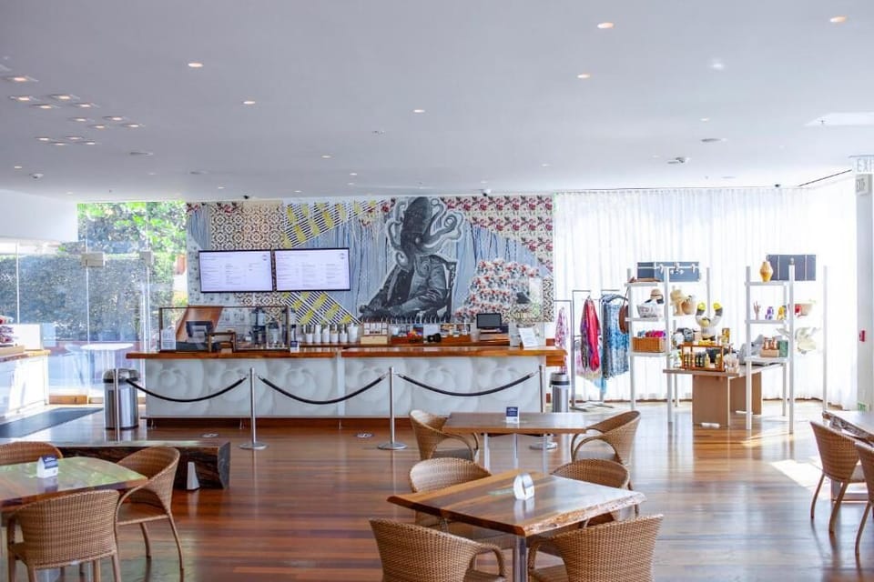 Step into a sunlit lobby with vibrant art and seating.