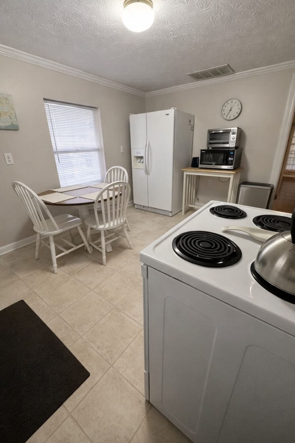 Large kitchen with full‑size refrigerator, additional countertop appliances, and