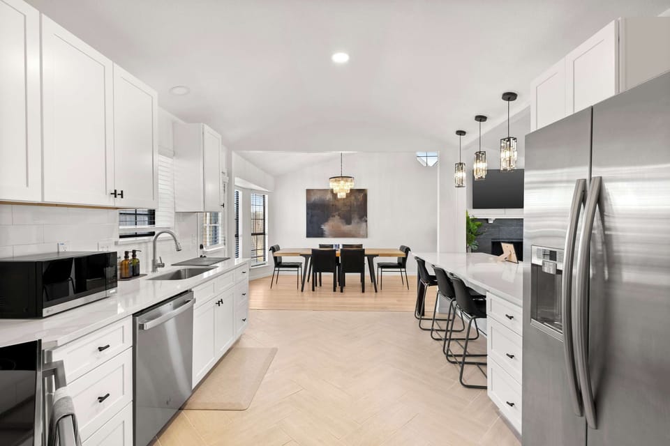 Sleek, fully equipped kitchen with modern finishes, stainless steel appliances, and bar seating—perfect for cooking, coffee, and casual meals.