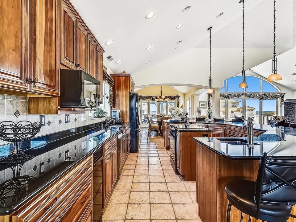 The glistening countertops in the kitchen reflect the natural light, elevating the inviting atmosphere that celebrates coastal living.