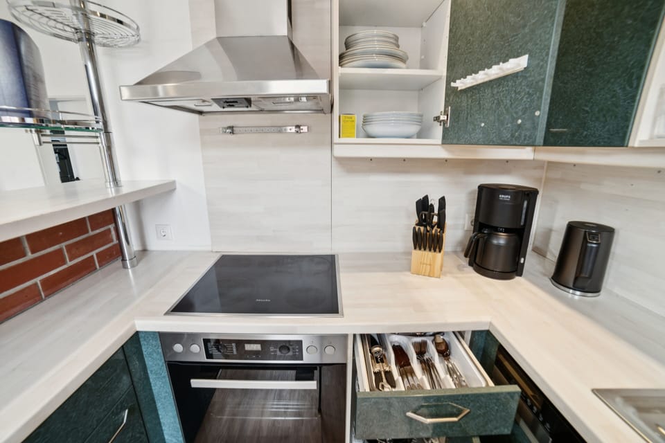 Kitchen equipment with stove, oven, dishes, kettle and coffee machine
