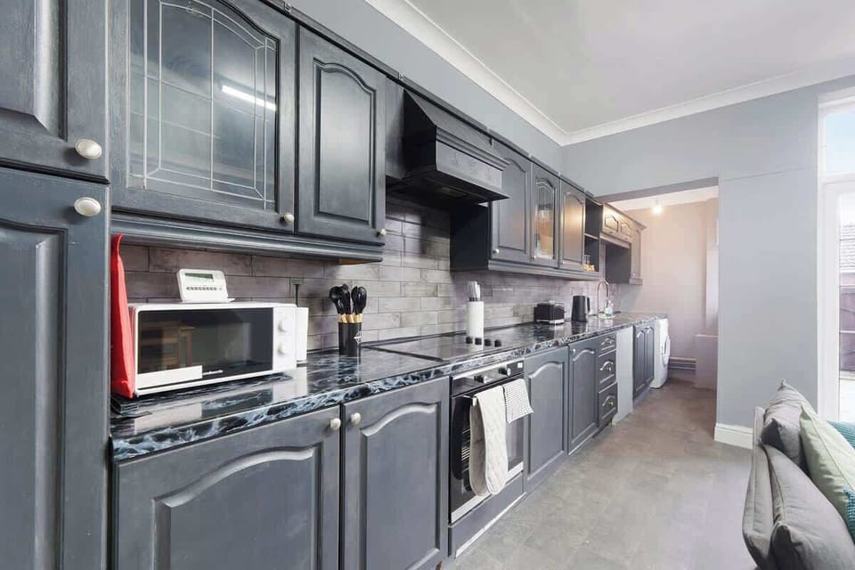 Kitchen equipped with all essentials, including an oven, fridge, and full cookware set.