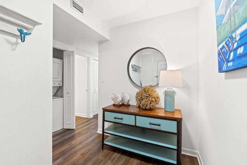 Charming entryway console with coastal accents, mirror, and soft lighting—welcoming you with beach-inspired style.