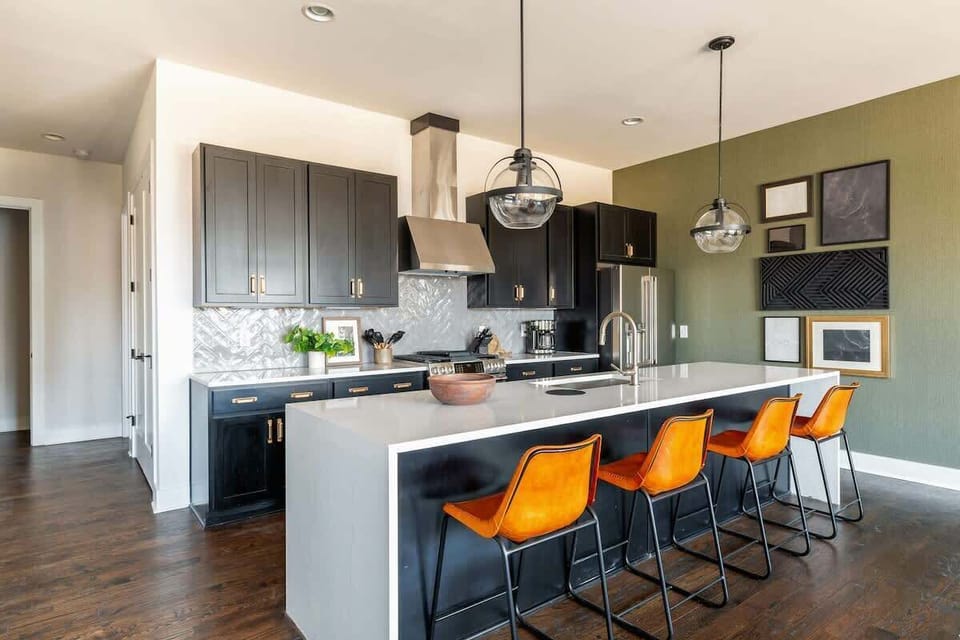 Unit 1 (2nd Floor): Fully equipped kitchen featuring stainless steel appliances and a kitchen island with bar seating for 4 guests.