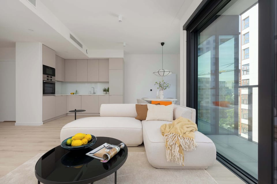 A spacious living room with a beige sectional and a black coffee table. The modern design invites comfort and style.