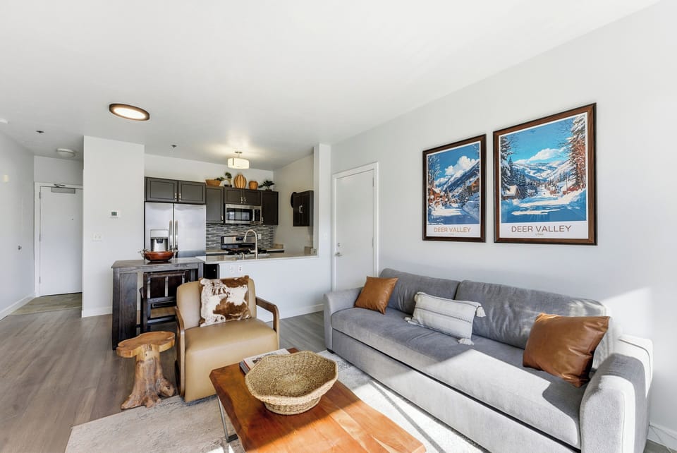 Cozy living room at The Mason in Deer Valley East featuring sofa seating, modern artwork, and open layout into the kitchen.