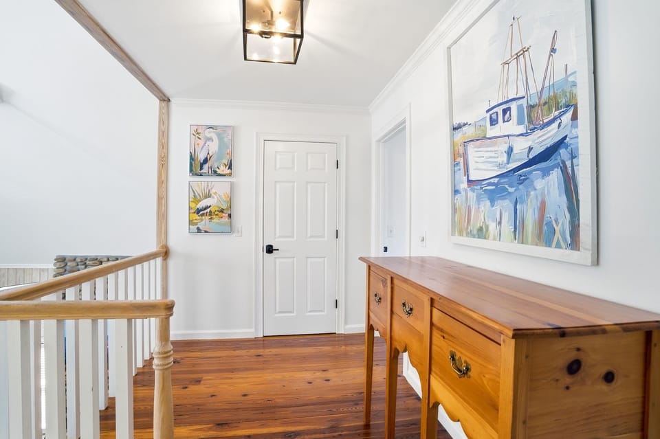 Upstairs Landing Leading to Bedrooms each with Bathroom - Open upstairs landing connecting the upper-level bedrooms, with hardwood floors and stair railing overlooking the main living area below.