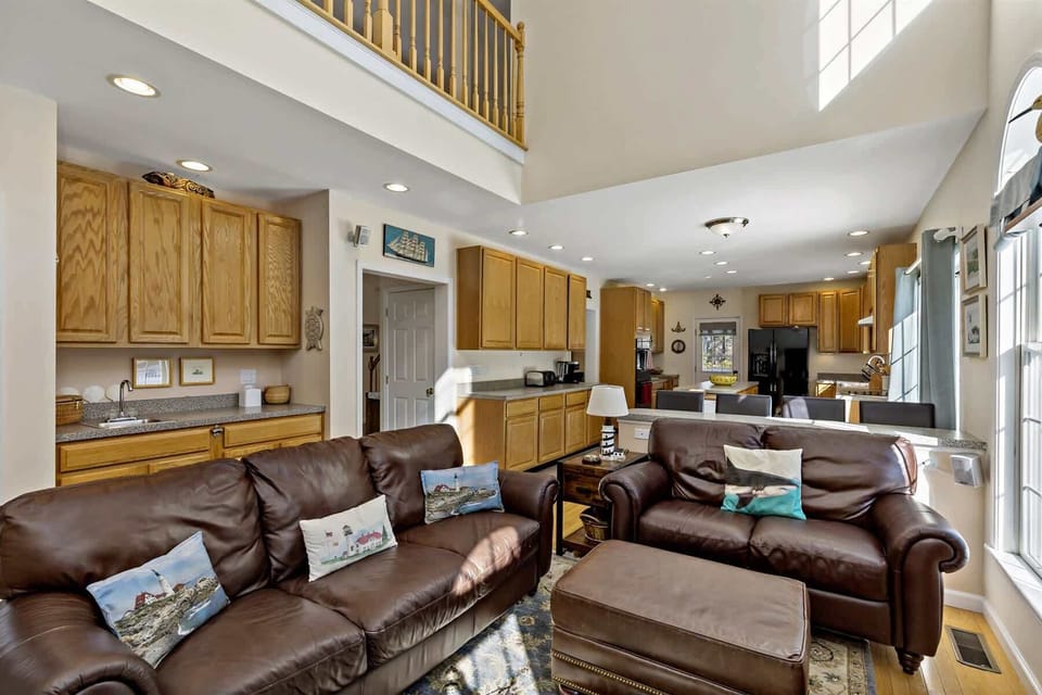 Comfortable leather seating in the sunlit great room, steps from the kitchen for easy entertaining and movie nights.